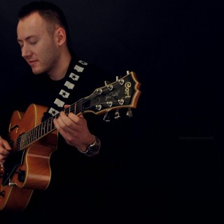 Strefa Dobrego Grania - zapisy na zajęcia gry na instrumentach - Łukasz Tadla z gitarą.