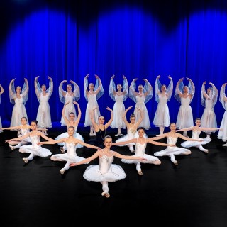 30-lecie Ogniska Baletowego - koncert jubileuszowy i wystawa fotografii - Grupa baletnic na scenie. Dziewczyny w białych strojach baletowych.
