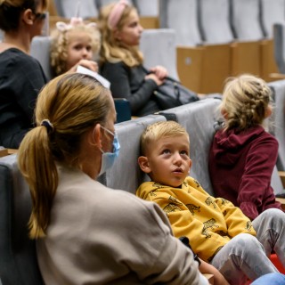 "Wystarczy być" - spektakl dla dzieci Teatru Maska - Grupa dzieci i dwie kobiety siedzą na widowni. - Fot : Przemysław Sroka