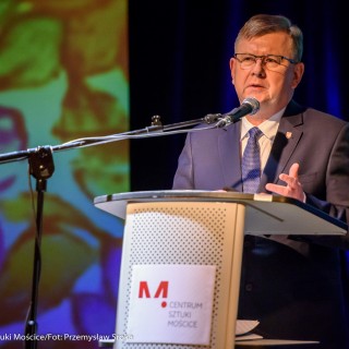 Podpisanie porozumienie na rzecz rozwijania i promowania kultury - Mężczyzna w garniturze i w okularach mówi do mikrofonu. - Fot: Przemysław Sroka