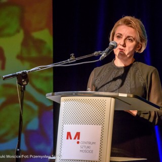 Podpisanie porozumienie na rzecz rozwijania i promowania kultury - Kobieta w czarnej sukience mówi do mikrofonu. - Fot: Przemysław Sroka