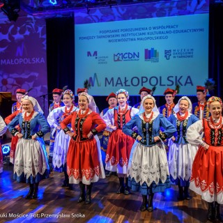 Podpisanie porozumienie na rzecz rozwijania i promowania kultury - Grupa kobiet i mężczyzn w strojach ludowych tańczy na scenie. - Fot: Przemysław Sroka