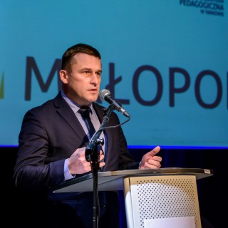 Podpisanie porozumienie na rzecz rozwijania i promowania kultury - Mężczyzna w garniturze mówi do mikrofonu - Fot: Przemysław Sroka