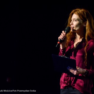 Festiwal Górnolotni 2021. Dzień pierwszy. - Kobieta mówi do mikrofonu trzymając w dłoni czarną podkładkę. - Fot : Przemysław Sroka