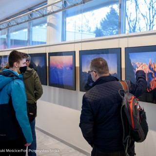 Festiwal Górnolotni 2021. Dzień pierwszy. - Grupa ludzi w maseczkach ogląda zdjęcia na wystawie. Jeden z mężczyzn wskazuje na zdjęcie przedstawiające górski krajobraz. - Fot : Przemysław Sroka