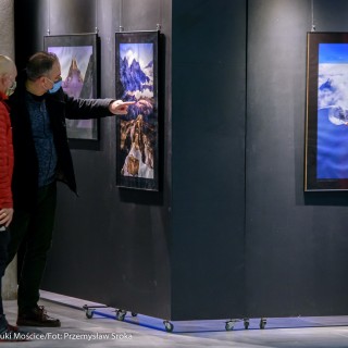 Festiwal Górnolotni 2021. Dzień pierwszy. - Dwóch mężczyzn w maseczkach ogląda zdjęcia na wystawie. Jeden z nich wskazuje palcem na zdjęcie przedstawiające górski krajobraz. - Fot : Przemysław Sroka