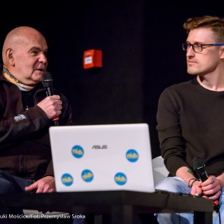Festiwal Górnolotni 2021. Dzień drugi. - Dwóch mężczyzn siedzi przed laptopem. Mężczyzna po lewej mówi do mikrofonu. - Fot : Przemysław Sroka