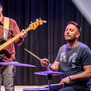 Akcja muzyczna na 50-lecie Centrum - Mężczyzna w koszuli gra na gitarze, obok niego mężczyzna w szarej koszulce gra na perkusji.  - Fot. : Przemysław Sroka