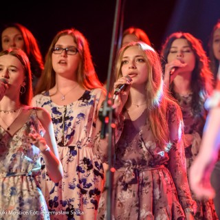 "Znów wędrujemy" - widowisko muzyczne - Grupa kobiet w kwiecistych sukienkach śpiewa, trzy z nich mają mikrofony.  - Fot. : Przemysław Sroka