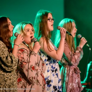"Znów wędrujemy" - widowisko muzyczne - Cztery kobiety w kwiecistych sukienkach śpiewają do mikrofonów.  - Fot. : Przemysław Sroka