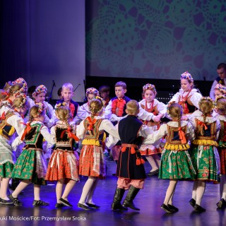 "Matulu, wyjrzyj na próg chaty" - występ Małych Świerczkowiaków - Grupa dzieci w strojach ludowych tańczy w kole na scenie, trzymając się za ręce. - Fot. : Przemysław Sroka
