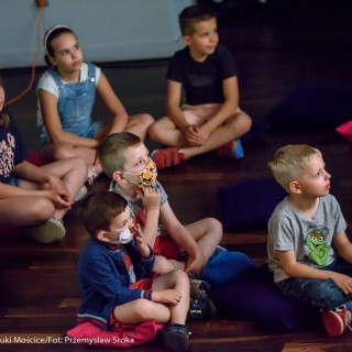 "Pan Dźwięk" - spektakl i warsztaty - Dzieci na widowni siedzą na poduszkach na podłodze i oglądają przedstawienie, dwójka z nich ma maseczki na twarzy.  - Fot. : Przemysław Sroka