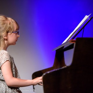 MiniLab - zakończenie roku 2020/2021 - Dziewczynka w okularach i sukience gra na fortepianie.  - Fot. :Przemysław Sroka