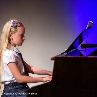 MiniLab - zakończenie roku 2020/2021 - Dziewczynka w białej bluzce i czarnej spódnicy gra na fortepianie. - Fot. :Przemysław Sroka