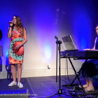 MiniLab - zakończenie roku 2020/2021 - Kobieta w kolorowej sukience śpiewa do mikrofonu, a kobieta w niebieskiej sukience gra na keyboardzie.  - Fot. :Przemysław Sroka