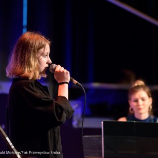 MiniLab - zakończenie roku 2020/2021 - Kobieta w sukience i czarnej katanie śpiewa do mikrofonu, a kobieta w niebieskiej sukience gra na keyboardzie.  - Fot. :Przemysław Sroka
