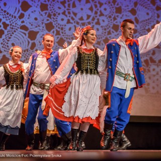 Świerczkowiacy - zakończenie sezonu artystycznego 2020/2021 - Kobiety w strojach ludowych tańczą w parach z mężczyznami w niebieskich strojach ludowych, którzy mają uniesioną jedną rękę. - Fot. :Przemysław Sroka