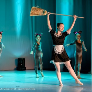 Ognisko baletowe - zakończenie sezonu artystycznego 2020/2021 - Kobieta w baletowej pozie w stroju służącej z miotłą w rękach, za nią tańczy grupa dzieci w strojach mysz. - Fot. :Przemysław Sroka