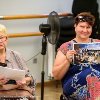 Czym są dla Was Mościce? - spotkanie - Dwie kobiety siedzą obok siebie trzymając w dłoni zdjęcia. Kobieta po prawej pokazuje zdjęcie w stronę obiektywu. - Fot.: Przemysław Sroka