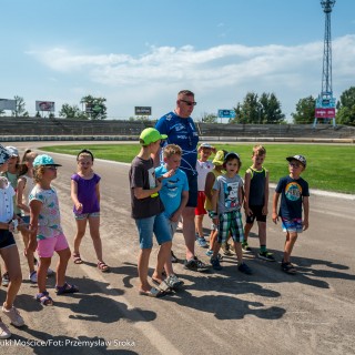 Wakacje w CSM - letnie warsztaty dla dzieci - Dzieci wraz z dorosłym mężczyzną spacerują po torze żużlowym. - Fot.: Przemysław Sroka