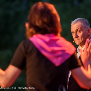 "Małe zbrodnie małżeńskie" - Muzyczne Tarasy 2021 - Kobieta w czarnej bluzce i różowej chustce jest obrócona do mężczyzny w marynarce, który na nią patrzy. - Fot.: Przemysław Sroka