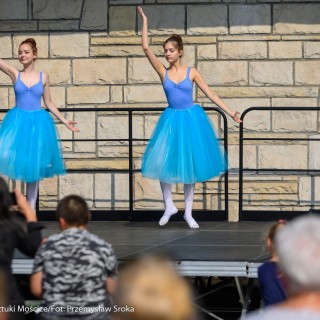 Festiwal Tarnowianie - dzień 2 - Dwie dziewczyny w niebieskich baletowych strojach tańczą na scenie, ludzie siedzą na widowni i oglądają występ.  - Fot. Przemysław Sroka i Michał Żurowski