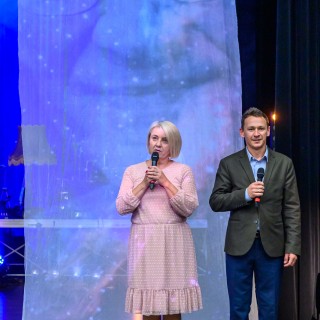 Festiwal Tarnowianie - dzień 3 - Kobieta w różowej sukience oraz mężczyzna w garniturze stoją na scenie, mężczyzna trzyma w ręku mikrofon, a kobieta do niego mówi.  - Fot. Przemysław Sroka