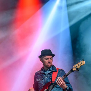 Koncert Pawła Domagały - Mężczyzna w kapeluszu gra na gitarze na scenie - Fot. Przemysław Sroka