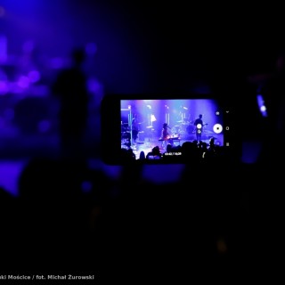 Koncert Kwiatu Jabłoni - Ktoś na widowni nagrywa koncert. To, co dzieje się na scenie, widać również na ekranie trzymanego przez mężczyznę smartfona. - fot. Michał Żurowski