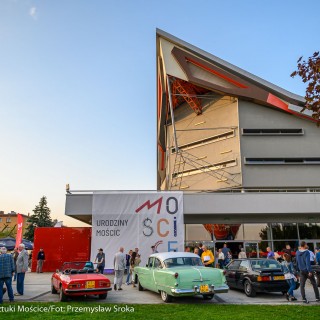 Urodziny Mościc - Kolorowe auta zaparkowane przed budynkiem CSM, ludzie chodzą wokół i oglądają je.  - Fot. Przemysław Sroka i Michał Żurowski