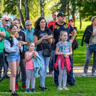 Urodziny Mościc - Grupa ludzi stoi na zewnątrz na trawie przy budynku CSM.  - Fot. Przemysław Sroka i Michał Żurowski