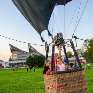 Urodziny Mościc - Grupa dzieci znajduje się w koszu balonu, linami przywiązanego do ziemi.  - Fot. Przemysław Sroka i Michał Żurowski
