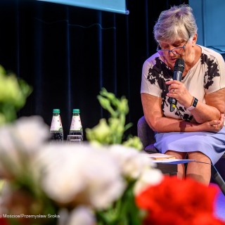 Senior w Centrum - Narodowe Czytanie - "Nad Niemnem" - Anna Krakowska siedzi z mikrofonem w dłoni i czyta fragment książki. - Fot: Przemysław Sroka