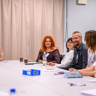 Warsztaty poetyckie Źródło - Uczestnicy warsztatów siedzą obok siebie przy stole i rozmawiają.  - Fot: Przemysław Sroka