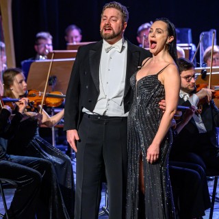 Koncert Sylwestrowy - Filharmonia Krakowska - Kobieta i mężczyzna śpiewają na scenie. Mężczyzna obejmuje kobietę. - Fot: Przemysław Sroka