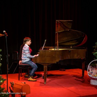 Koncert Pianistów Laboratorium Artystycznego - Chłopiec gra na fortepianie. Obok niego siedzi kobieta. - Fot: Przemysław Sroka