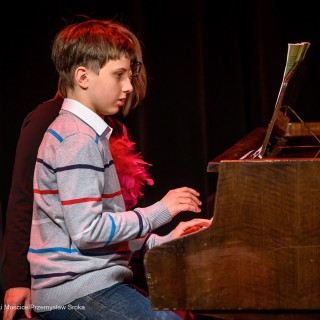 Koncert Pianistów Laboratorium Artystycznego - Chłopiec gra na fortepianie. Obok niego siedzi kobieta. - Fot: Przemysław Sroka